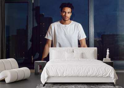 African American man in a white T-shirt sitting on a window. Mock-up. Wall mural