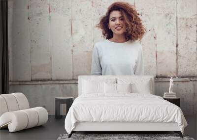 Curly haired girl with freckles in blank grey sweatshirt on the street. Mock up. Wall mural