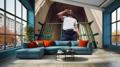 Stylish african american man in white blank t-shirt and sunglasses. Mock-up. Wall mural