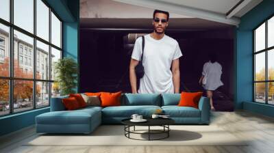 Stylish african american man in white blank t-shirt and sunglasses. Mock-up. Wall mural