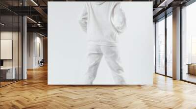 Woman with thick curly hair in a white suit from a hoodie and sweatpants back view. Wall mural