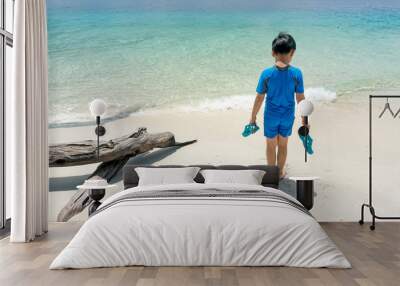 Asian little boy walking on a beautiful tropical beach enjoying on a exotic island during summer vacation. Wall mural