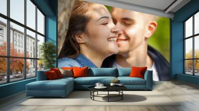 Young couple having fun, talking, flirting in a sunny park in springtime, beautiful, romantic mood Wall mural