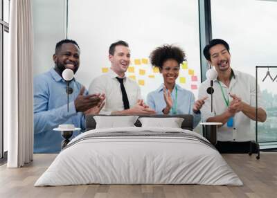 A group of four people are clapping and smiling in a business setting. Scene is positive and celebratory, as the group is likely congratulating each other on a job well done or a successful project Wall mural