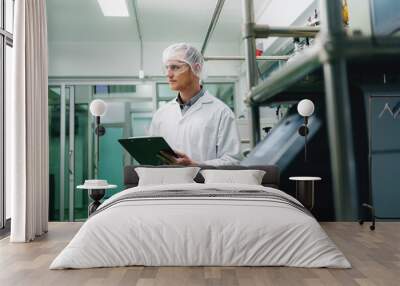 A man in a lab coat holding a clipboard. He is wearing a white lab coat and a white hat Wall mural