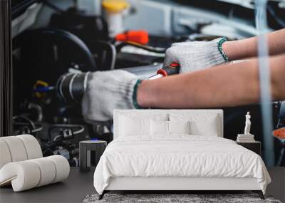 Close-up of a female repairman's hand. Car care and maintenance, hands-on car mechanic using a wrench to fix the car engine problem. Audit and Service Concepts Wall mural