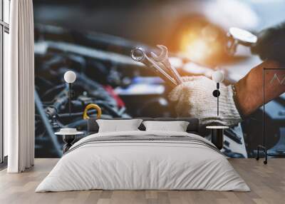 Close-up photo of a car mechanic working on a car engine in a mechanics repair service garage. A uniformed mechanic is working on a car service. Work in the garage, repair and maintenance services. Wall mural