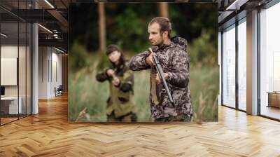 hunters in camouflage clothes ready to hunt with hunting gun Wall mural