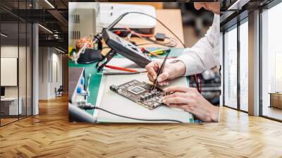 woman repairing computer hardware in service center. Repairing and fixing service in lab. Electronics repair service concept. Wall mural