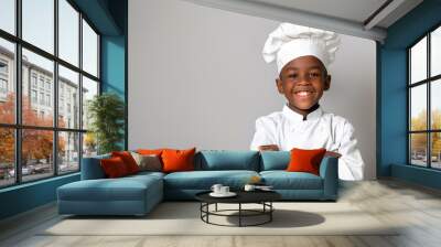 A cute happy smiling young African American black boy dresses like a chef on a plain white background with copy space for text. Wall mural