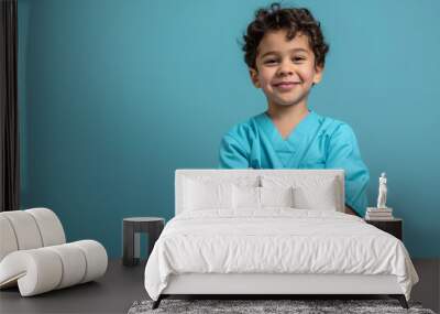 A cute happy smiling young Arab boy dresses blue scrubs like a nurse on a plain blue background with copy space for text. Wall mural