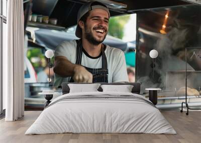 A happy and smiling male entrepreneur is cooking inside his food truck. Wall mural