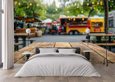 Empty wooden tables on blurred food truck festival and bright decoration lights as a background. Wall mural