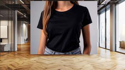 Mockup of clothes worn by a model. Close up of full upper body part from hip to neck on plain background. A woman wearing a basic black t-shirt on a plain light grey background. Wall mural