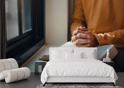 A man hands folded holy bible by the window in library and church Wall mural