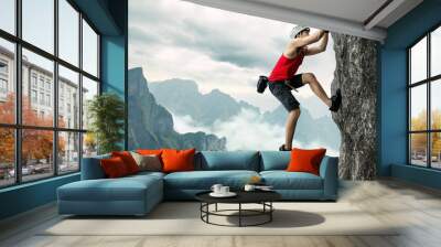 Asian man rock climber in black pants climbing on the cliff. Wall mural