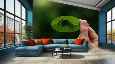 Hand of human is holding green leaf with carbon footprint, renewable energy carbon and business goverment concept. Wall mural