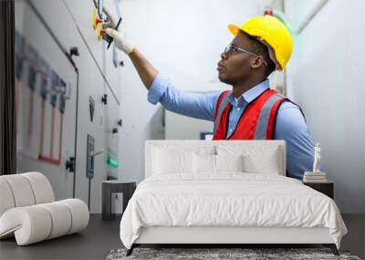 Electrical engineer working in control room. Electrical engineer man checking Power Distribution Cabinet in the control room Wall mural