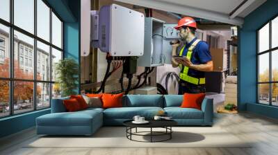 Electrical engineer working in control room. Electrical engineer man checking Power Distribution Cabinet in the control room Wall mural