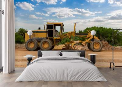 Grader Road Construction Grader industrial machine on construction of new roads. the blade of a motor grader in the process of leveling a sandy road foundation. Grader is working on road construction. Wall mural