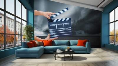 Man hands holding movie clapper.Film director concept.camera show viewfinder image catch motion in interview or broadcast wedding ceremony, catch feeling, hand hold a Film Slate with storm cloud. Wall mural