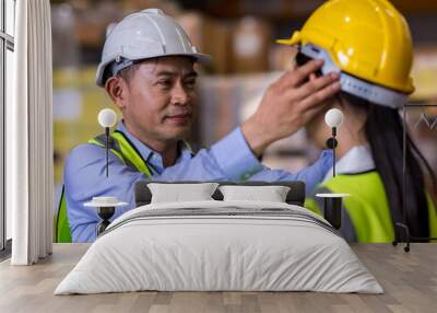 Man puts a safety helmet on woman at factory or plant site. Business heir concept. Happy lover wearing safety helmet on together	 Wall mural