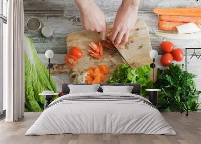 cooking and home concept - close up of male hand cutting tomato on cutting board with sharp knife Wall mural