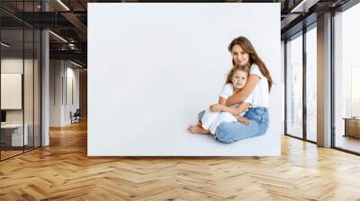 Happy mom and daughter cuddling on a white background. Happy family concept Wall mural