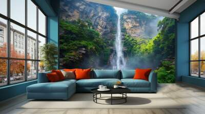 A low angle shot of a majestic waterfall cascading down a rocky cliff Wall mural