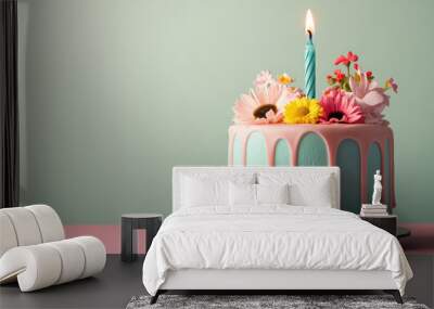 A cake with a lit candle on top and flowers around it Wall mural