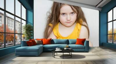 a portrait of emotional upset pensive and meditative little girl on a white background Wall mural