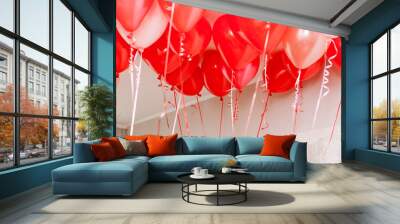 Lots of red and white balloons with curly ribbons in white room for romantic and children's holidays with copy space background Wall mural