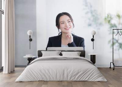 Close-up of a woman in a pose such as troubled (thinking, remembering) thinking about using a computer in an office, with space for photocopying Wall mural