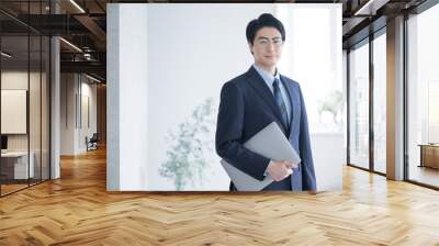 Young businessmen holding computers and looking at the camera, such as tax accountants, accountants, consultants professionals, etc. There is a copy space on the right. Wall mural