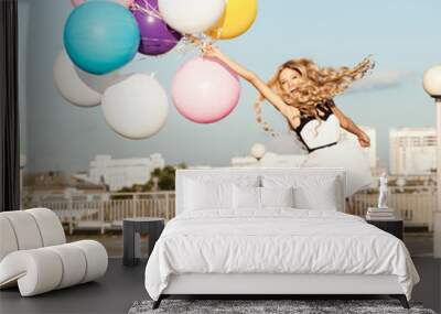 Happy young woman with colorful latex balloons Wall mural