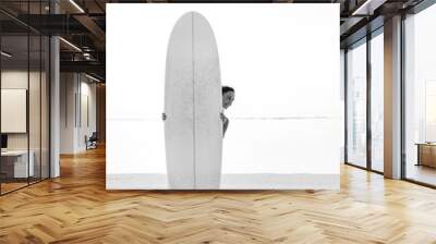 young smiling brunette (girl, woman) looking out, standing behind white surfboard Wall mural