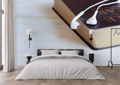 closed bible with headphones or earbuds on white wood Wall mural