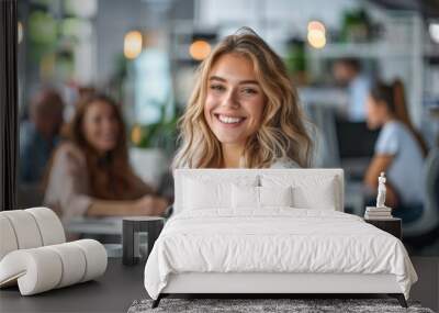 A young happy businesswoman sitting at a modern office desk surrounded Wall mural