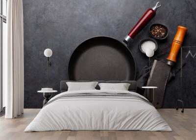 Frying pan, utensils and ingredients on kitchen table Wall mural