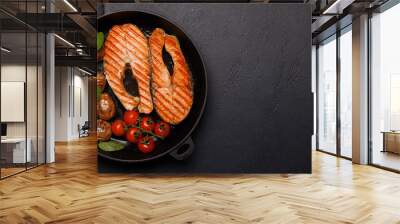 Grilled salmon steaks and potatoes sizzling in a frying pan Wall mural