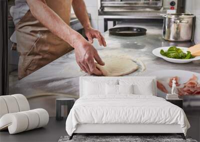 Processing of the pizza dough by the pizza maker at Italian restaurant kitchen  Wall mural