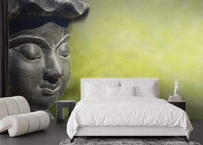 Buddha Face in Sunlight with Blurred Green Background Wall mural