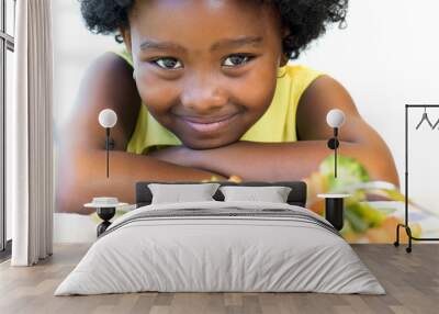 African girl in front of vegetable dish. Wall mural