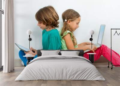 Two kids socializing with laptop and tablet. Wall mural