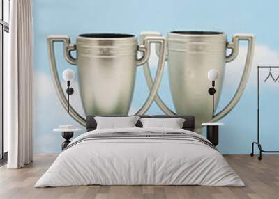 two trophies on green with sky background Wall mural