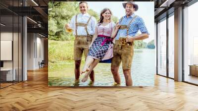 friends having fun on Bavarian RIver(isar) Two men carry woman over the river Wall mural