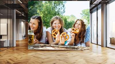 Friends in Bavarian costume celebrate on the river Isar and drink beer. Oktoberfest munich Wall mural