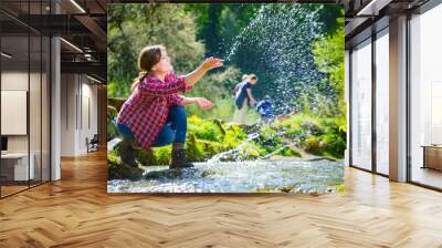 happy young woman smiling and touching water in rapid river  Wall mural