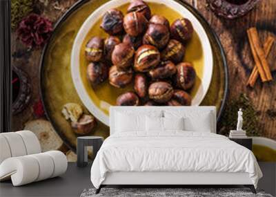 Roasted chestnuts for Christmas served on a wooden table with red mulled wine Wall mural