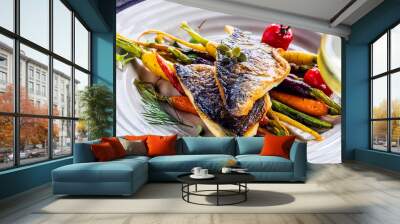 top view of delicious fish with vegetables on white plates and wine glasses on grey surface Wall mural